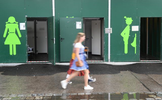 26 September 2022, Bavaria, Munich: Two ladies walk past toilets at the Oktoberfest. The Wiesn takes place from September 17 to October 3, 2022. Photo: Felix Hörhager\/dpa