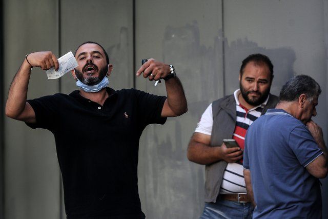 26 September 2022, Lebanon, Beirut: A Lebanese depositor waves with a cheque that he couldn\