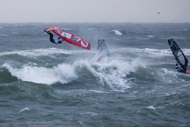 26 September 2022, Schleswig-Holstein, Westerland\/Sylt: Antony Ruenes (l) from France shows a jump in the freestyle discipline at the Windsurf World Cup off Sylt. The season finale in the battle for the world championship titles runs until October 3, 2022. Photo: Frank Molter\/dpa