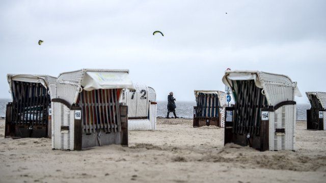 26 September 2022, Lower Saxony, Norden: Walkers walk on the beach of Norddeich in the rain. Photo: Sina Schuldt\/dpa
