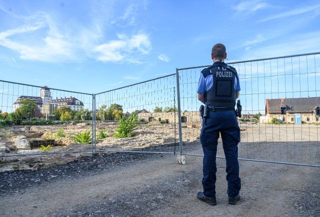 05 October 2022, Saxony, Dresden: A policeman stands in front of the site where a 250-kilogram bomb from World War II was found. The bomb had been discovered during construction work on Friedrichstraße. Photo: Robert Michael\/dpa