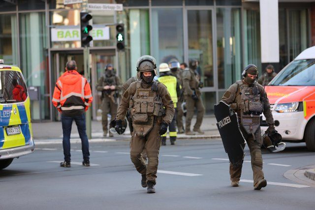 06 October 2022, North Rhine-Westphalia, Bielefeld: Emergency forces cross the street in front of a bank in downtown Bielefeld. A man threatened to cause an explosion with two gas cylinders in a store in Bielefeld and was overpowered by special forces. Photo: Christian Müller\/Westfalennews\/dpa