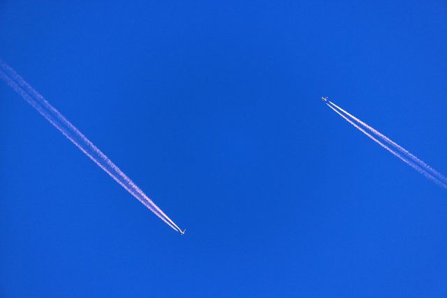 06 October 2022, Mecklenburg-Western Pomerania, Pokrent: Two commercial airliners meet in the sky and are illuminated by the setting sun. Photo: Jens Büttner\/dpa
