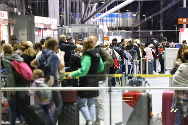 01 October 2022, North Rhine-Westphalia, Cologne: Travelers at Cologne\/Bonn Airport stand in lines at the counters in the departure hall. At the start of the fall vacations in North Rhine-Westphalia, there are again waiting times at the airports. Photo: Thomas Banneyer\/dpa