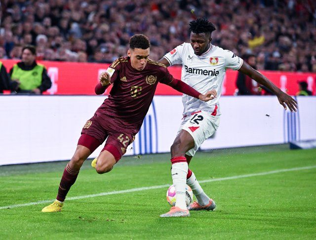 30 September 2022, Múnich;: Bayern Munich striker Jamal Musiala battles with Bayer Leverkusen defender Edmond Tapsoba in the Bundesliga match between the two clubs on matchday eight. Bayern Munich\