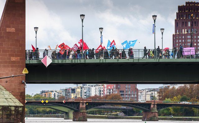 01 October 2022, Hessen, Frankfurt\/Main: Demonstrators walk across the Old Bridge, which crosses the Main River, during the peace movement\