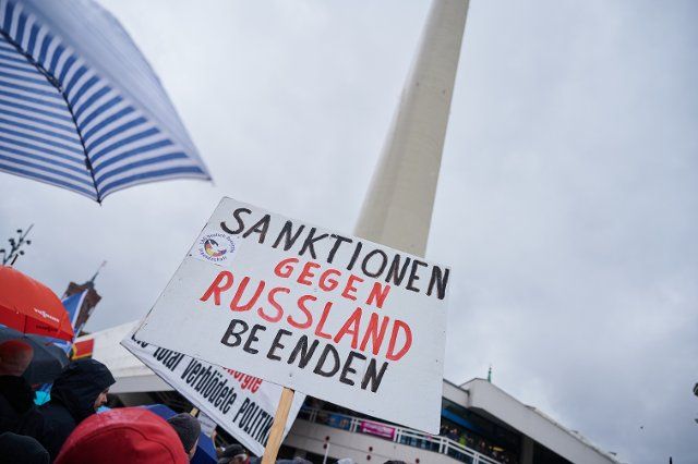 01 October 2022, Berlin: People demonstrate on Alexanderplatz under the slogan "End the sanctions - craftsmen for peace". "End sanctions against Russia" is written on a poster. The right-wing extremist magazine "Compact" had advertised the protest action in advance. Photo: Annette Riedl\/dpa
