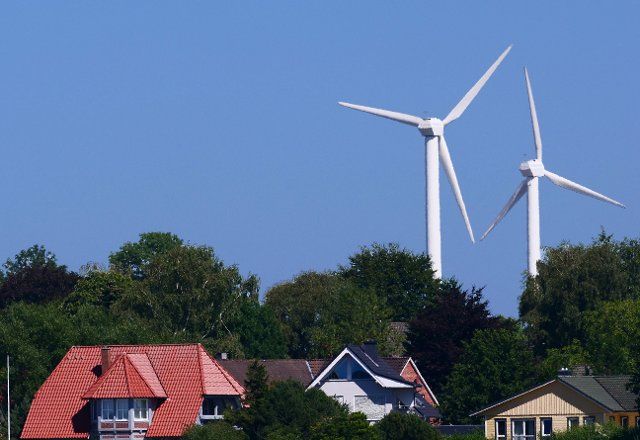 12 August 2022, Schleswig-Holstein, Kappeln: 12.08.2022, Kappeln on the Schlei. Windmills for power generation stand behind residential houses near Kappeln. Photo: Wolfram Steinberg\/dpa Photo: Wolfram Steinberg\/dpa