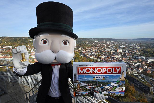 20 October 2022, Thuringia, Jena: Mr. Monopoly presents a new Monopoly Edition Jena on the observation deck of the Jentower high above the rooftops of the city. The new version of the well-known board game also includes a gold-colored miniature Jentower as a token. Photo: Martin Schutt\/dpa