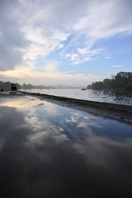 22 October 2022, Hamburg: Blue sky and veil clouds over the Außenalster are reflected in a puddle at the Krugkoppelbrücke pier. Photo: Jonas Walzberg\/dpa
