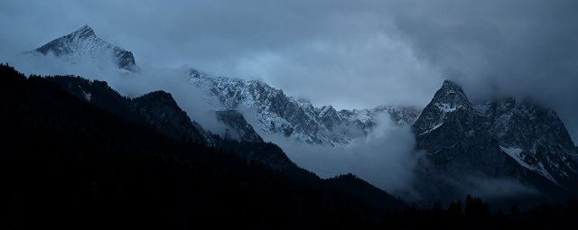 20 November 2022, Bavaria, Garmisch-Partenkirchen: Morning fog hangs between Alpspitze (l) and Waxensteine (r) in Höllental. The peaks of the Wetterstein mountains are covered with a thin layer of snow after a light snowfall during the night. Photo: Angelika Warmuth\/dpa