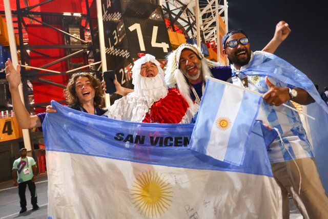 30 November 2022, Qatar, Doha: Soccer, World Cup 2022 in Qatar, Poland - Argentina, preliminary round, Group C, Matchday 3 at Stadium 974 in Doha, fans from Argentina stand with flags outside the stadium. Photo: Tom Weller\/dpa