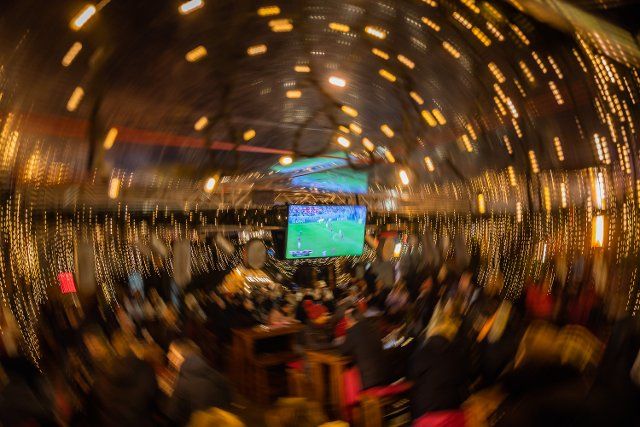01 December 2022, Berlin: Soccer: World Cup, Costa Rica - Germany, preliminary round, Group E, match day 3, Public Viewing Berlin. Visitors follow the broadcast of the match at the Christmas market on Breitscheidplatz. (Wiping effect by rotating the camera). Photo: Christoph Soeder\/dpa
