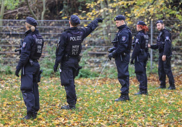 29 November 2022, North Rhine-Westphalia, Krefeld: Police officers search a meadow near a crime scene with iron bars. After the shooting of a 42-year-old man on the open street, the homicide squad in Krefeld is searching for two men. Photo: Oliver Berg\/dpa