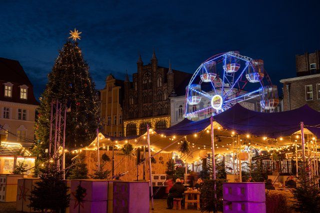 28 November 2022, Mecklenburg-Western Pomerania, Stralsund: Colorful lights shine at the Christmas market on the Alter Markt. The Christmas markets in Mecklenburg-Vorpommern and the shopping miles attract shoppers with colorful lights to the city centers. Photo: Stefan Sauer\/dpa