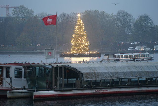 30 November 2022, Hamburg: The Alster Christmas fir lights up on the Binnenalster. Photo: Marcus Brandt\/dpa