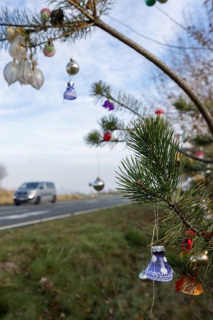 30 November 2022, Saxony, Bannewitz: A fir tree was decorated with Christmas decorations at the freeway access road near Bannewitz at Christmas time. This tree is probably intended to remind motorists of the reflective season. Photo: Daniel Schäfer\/dpa