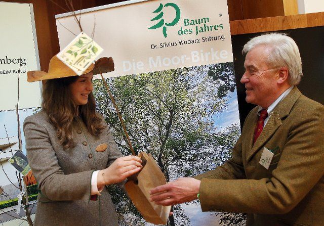 30 November 2022, Berlin: Stefan Meier, President of the Dr. Silvius Wodarz Foundation, attends the proclamation of the Tree of the Year 2023 and presents Johanna Werk, German Tree Queen, with a specimen of the Moor Birch. Photo: Wolfgang Kumm\/dpa