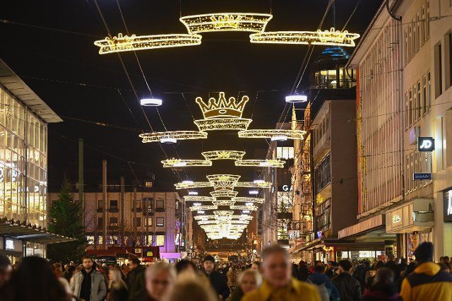 25 November 2022, Hessen, Kassel: Visitors stroll along the illuminated Königsstraße. Photo: Uwe Zucchi\/dpa