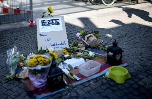 23 July 2018, Germany, Berlin: Flowers and messages of solidarity lying on the floor at the Schoeneweide S-Bahn station in Cajamarca Square. An unknown assailant sprayed two homeless people and their posessions with a liquid and set them on fire. Photo: Britta Pedersen\/dpa-Zentralbild\/