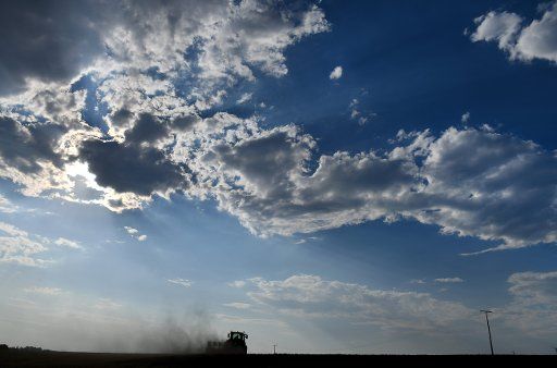 31 July 2018, Germany, Mackenrode: A farmer ploughs a dry field and drags a cloud of dust behind him. Photo: Frank May\/
