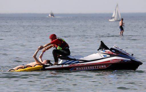 07 August 2018, Germany, Warnemuende: Pilot Sven Hennig and extra Torge Strohbach demonstrate a rescue operation on the Baltic Sea at the official launch of two new "Rescue Water Crafts" by the water safety of the German Red Cross. For their use as water rescue vehicles, two jet skis were converted and fitted with flashing lights and a rescue board. Photo: Bernd Wüstneck\/