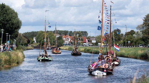 11 August 2018, Germany, Carolinensiel: Traditional sailing ships sail along the Harle River during the "WattenSail 2018" event. Photo: Mohssen Assanimoghaddam\/