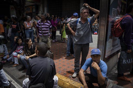 30.08.2018, Venezuela, Caracas: Travellers are waiting for a bus during a power failure. A power outage has paralyzed the subway in the Venezuelan capital. Photo: Rayner Pena\/