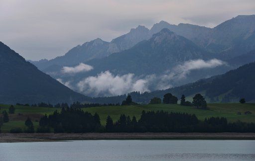 30 August 2018, Germany, Dietringen: The Alps are covered in clouds behind the Forggen lake, which leads only a little water. Photo: Karl-Josef Hildenbrand\/