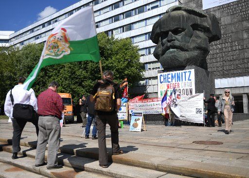08 September 2018, Germany, Chemnitz: A rally entitled "Stateless" takes place in front of the Karl Marx Monument in Chemnitz. After the killing of Chemnitz, about two dozen people gathered at another rally until Saturday noon. Photo: Hendrik Schmidt\/dpa-Zentralbild\/