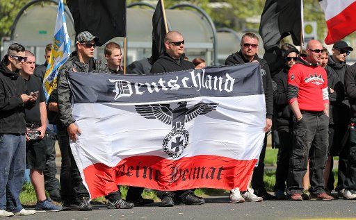 01 May 2018, Saxony, Chemnitz: Participants of a demonstration of right-wing extremists stand with a black-white-red flag on a street. Applicant is the neo-Nazi party "Der III. Away". Photo: Jan Woitas\/dpa-Zentralbild\/