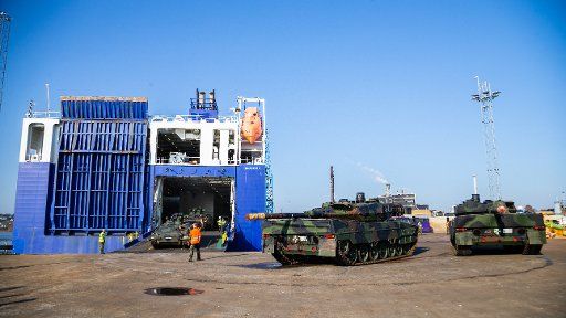 11 October 2018, Norway, Fredrikstad: Leopard 2 tanks (right) are standing in front of the RoRo ship after the shipment for the big manoeuvre of Nato "Trident Juncture". Nato wants to train with "Trident Juncture" from 25 October on for the so-called alliance case. Photo: Mohssen Assanimoghaddam\/