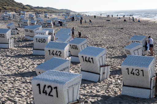 13 October 2018, Schleswig-Holstein, Westerland: 13 October 2018, Germany, Westerland: Holidaymakers enjoy the summery autumn weather next to their beach chairs on the main beach of Westerland. Photo: Swen Pförtner\/