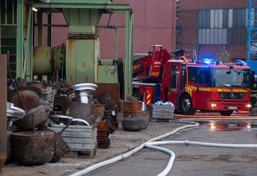 21 November 2018, North Rhine-Westphalia, Kefeld: After a violent explosion, firefighters and rescue workers are on duty in an iron foundry. Two employees were injured in the accident. The incident occurred in the melting furnace on the foundry premises. The explosion set fire to the roof of the 3000 square metre factory building. Photo: Arnulf Stoffel\/