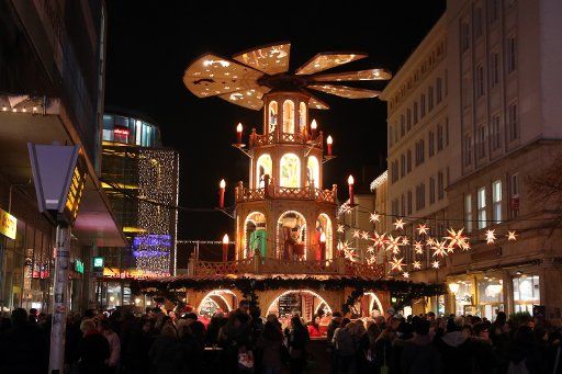 26 November 2018, Saxony-Anhalt, Magdeburg: Visitors walk over the Christmas market, which takes place every year at the Old Market in front of the Old Town Hall, the St. John\