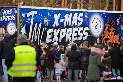 05 December 2018, Lower Saxony, Osnabrück: Refugees are waiting for the issue of toy gifts. The Christmas presents will be distributed by a Christmas truck ("x-mas Express") to refugee children on the grounds of the Landesaufnahmebehörde. Together with Janina Martig Logistics, the Til Schweiger Foundation collects gifts for disadvantaged children. Photo: Friso Gentsch\/