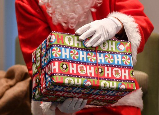 21 December 2018, Berlin: A gift pack in the hands of a Santa Claus. Photo: Jens Kalaene\/dpa-Zentralbild\/