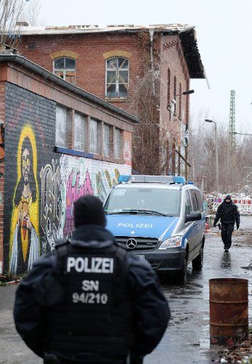 15 January 2019, Saxony, Leipzig: Policemen are standing in front of a former transformer station of the railway. In the Connewitz district of Leipzig, police have been searching an occupied property since this morning. According to the police, the site has been occupied since mid-2016. The property is owned by Deutsche Bahn. Photo: Sebastian Willnow\/dpa-Zentralbild\/