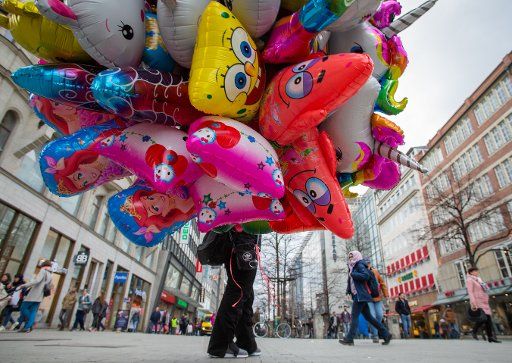 19 February 2019, Lower Saxony, Hannover: A balloon salesman is standing in the city centre with his colourful goods. Photo: Raphael Knipping\/