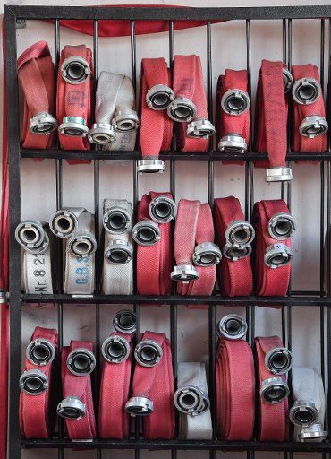 20 February 2019, Brandenburg, Angermünde: Rolled up fire hoses are arranged in a shelf of the volunteer fire brigade. Photo: Patrick Pleul\/dpa-Zentralbild\/