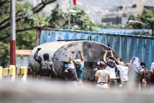 25 February 2019, Colombia, Cucuta: Demonstrators are trying to get the trailer of a tanker truck that is blocking the Simon Bolivar bridge on the border between Colombia and Venezuela off the bridge. The bridge is full of stones after the clashes on 23.02.2019. The attempt of the Venezuelan opposition to bring relief supplies from Colombia and Brazil to Venezuela failed due to the blockade of the border by the Venezuelan armed forces. Photo: Rafael Hernandez\/