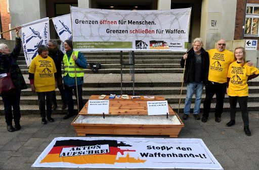 26 February 2019, Schleswig-Holstein, Kiel: Demonstrators of the German Peace Society are standing at the entrance of the regional court during a vigil. Three former managers of the Sig Sauer group are responsible for pistol deliveries to Colombia. Photo: Carsten Rehder\/