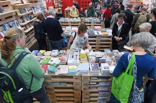 22 March 2019, Saxony, Leipzig: Visitors to the Leipzig Book Fair leaf through books at the Swiss Independent Publishers\