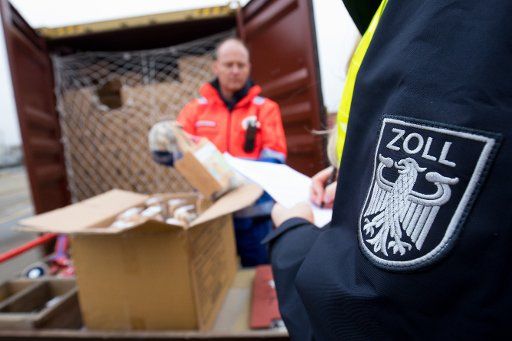 21 March 2019, Hamburg: Customs officers at the Hamburg customs office check the contents of a container at a container terminal in the port of Hamburg. Photo: Christian Charisius\/