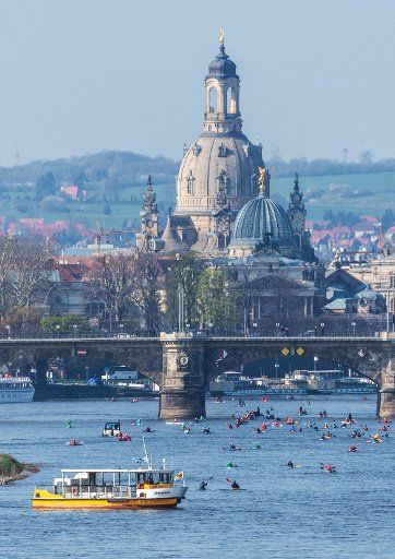 07 April 2019, Saxony, Dresden: Paddlers are on the Elbe in the direction of the historic old town with the Frauenkirche. The association Kanusport Dresden e.V. had invited to the 12th "Great Dresdner Anpaddeln". Photo: Robert Michael\/dpa-Zentralbild\/