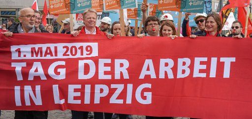 01 May 2019, Saxony, Leipzig: DGB Chairman Reiner Hoffmann (2nd from left) stands behind a banner with the inscription "1 May 2019 - Labour Day in Leipzig". The central rally of the DGB on Labour Day took place in Leipzig. Photo: Peter Endig\/
