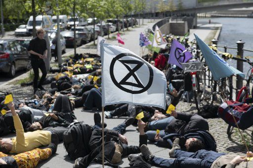 06 May 2019, Berlin: Demonstrators lie on the ground during an action of the Extinction Rebellion movement in the government district. The occasion is the new UN report on biodiversity. According to the study, up to one million animal and plant species are threatened with extinction. Photo: Paul Zinken\/