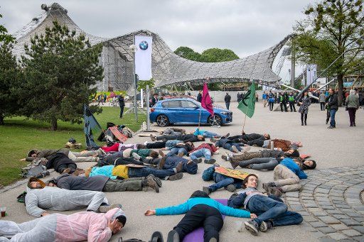 16 May 2019, Bavaria, Munich: Activists of the "Extinction Rebellion Munich" group lie in front of the Olympic Hall, where the BMW Annual General Meeting is being held. With the protest action the participants want to protest against the destruction of the planet by the car manufacturer. Photo: Sina Schuldt\/