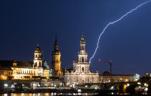 10 June 2019, Saxony, Dresden: Lightning strikes during a thunderstorm in the evening into the historical old town scenery with the Ständehaus (l-r), the Hausmannsturm and the Hofkirche. Photo: Robert Michael\/dpa-Zentralbild\/