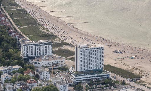 14 June 2019, Mecklenburg-Western Pomerania, Warnemünde: Tourists populate the beach around the Hotel Neptun at the Baltic Sea Photo: Axel Heimken\/